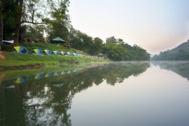 Yaz tatili için Erivan Şelalesi Ulusal Parkı 'ndaki yeşil ormanda su yansıtmalı kamp çadırı ve kulübe kampı.