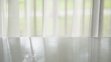 Üst ve yan veya 45 derece görünüm beyaz ahşap masa veya boş masa ön pencere ve rüzgar iş yerindeki ofis sallanan şeffaf beyaz perde eser ürün veya nesne ve arkaplan veya sahne 4K