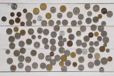 Üst görünüm beyaz ahşap masa ya da zemin üzerinde çok uluslu madeni para iş geçmişi veya mali değişim ve tasarruf para ve banka para yatırımı