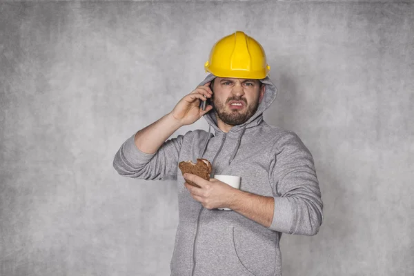 Worker ate a sandwich and talking on the phone — Stock Photo, Image