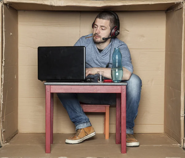 Intern with a cigarette in his mouth and alcohol on the table — Stock Photo, Image