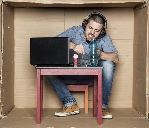 Studenten ger ut en cigarett i ett glas med alkohol — Stockfoto