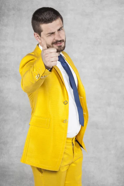 Бизнесмен в золотом костюме показывает большие пальцы вверх — стоковое фото