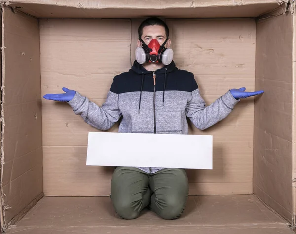 Hombre Una Máscara Protectora Sienta Una Caja Cartón Sostiene Tablero — Foto de Stock