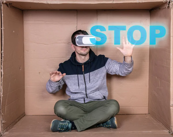 man wears virtual reality glasses, shows stop sign