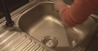  Kadın eli lavaboyu süngerle yıkıyor.