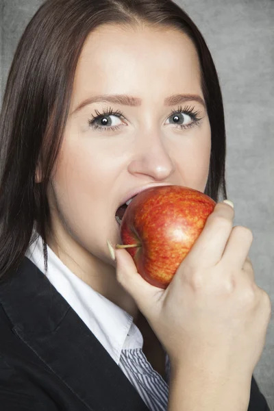 Femme d'affaires mordre une pomme — Photo
