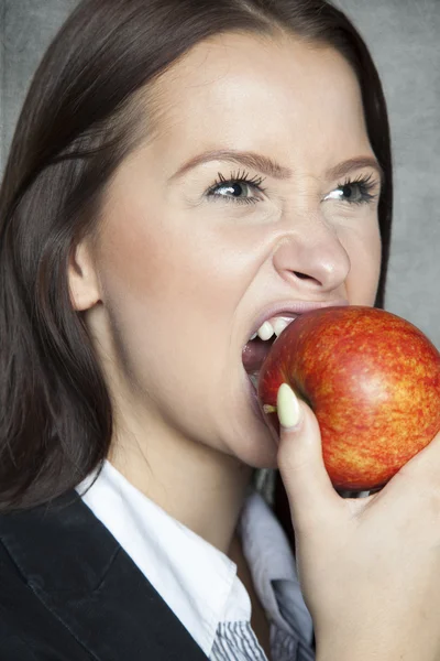 Femme d'affaires mordre une pomme — Photo