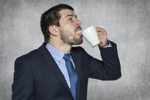 Businessman sips sandwich — Stock Photo, Image