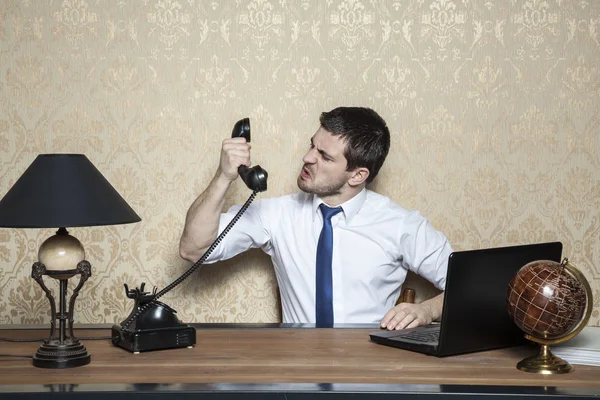 Empresário gritando para o aparelho — Fotografia de Stock