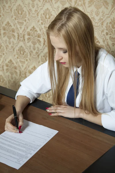 Mladá žena podepíše smlouvu — Stock fotografie