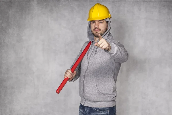 Builder on grey background, pointing at you — Stock Photo, Image