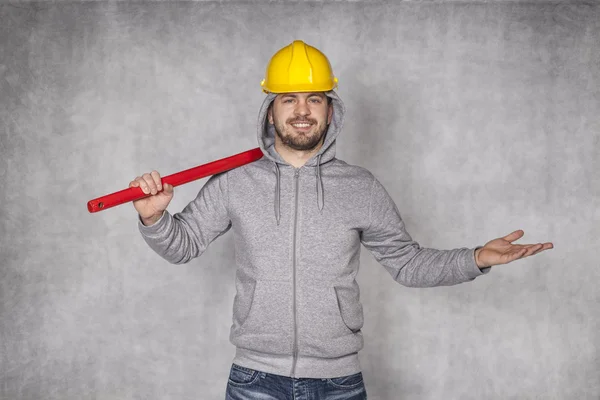 Vrolijke werknemer op de grijze achtergrond — Stockfoto