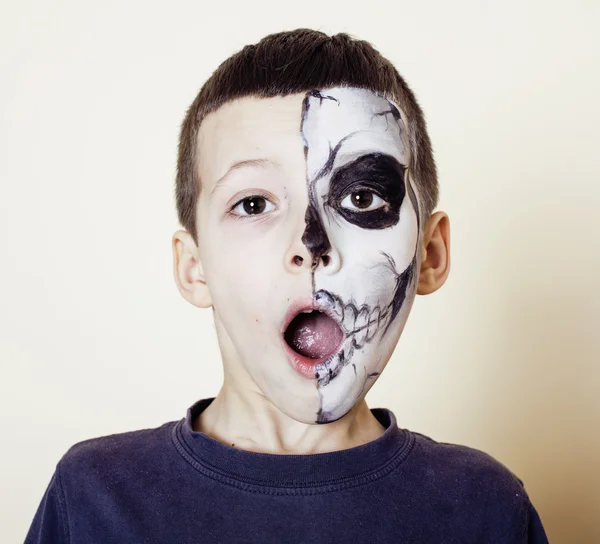 Little cute boy with facepaint like skeleton to celebrate halloween