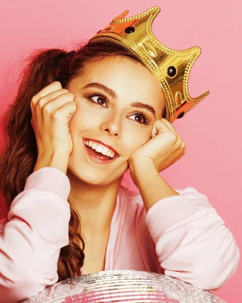 young cute disco girl on pink background with disco ball and crown