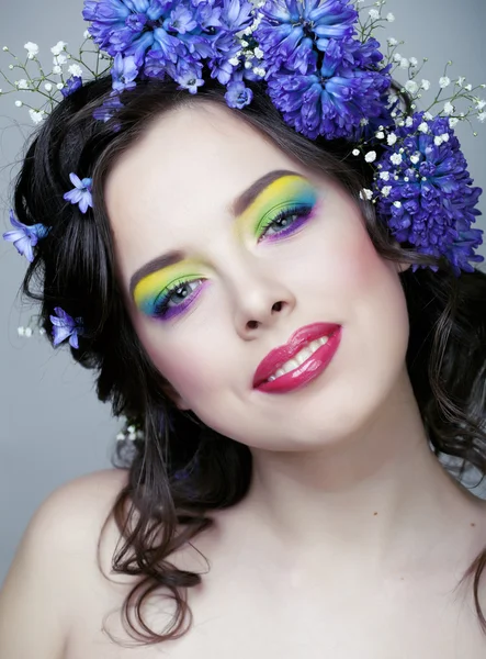 Beauty young woman with flowers and make up close up, real spring beauty