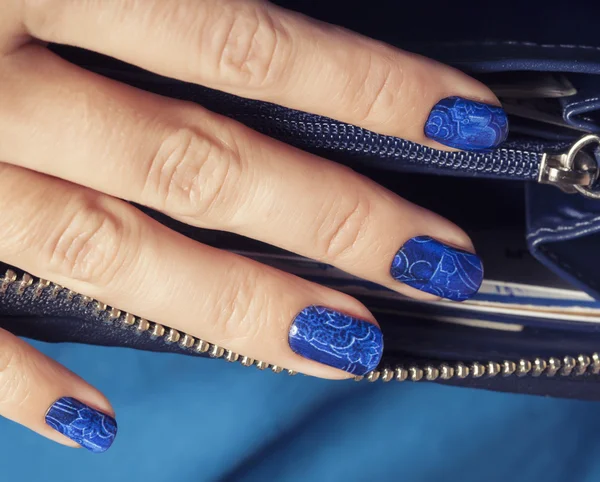 pretty fingers, deep blue manicure close up with purse