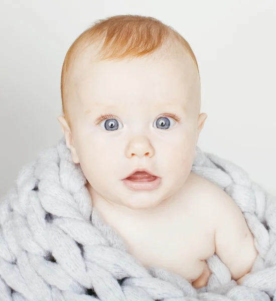 little cute red head baby in scarf all over him close up isolated, adorable kid