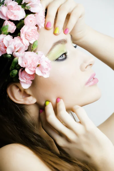 Beauty young real woman with pink flowers and make up closeup, spa salon