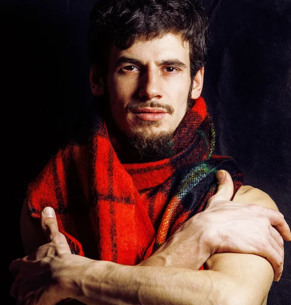 portrait of handsome man warmed up in scarf, smiling closeup dark background