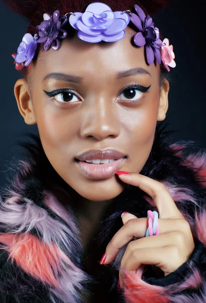 young pretty african american woman in spotted fur coat and flowers jewelry on head smiling sweet etnic make up bright