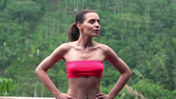 Сексуальная, спортивная женщина стоит на террасе — стоковое видео