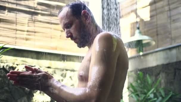 Чоловік миє тіло під душем — стокове відео