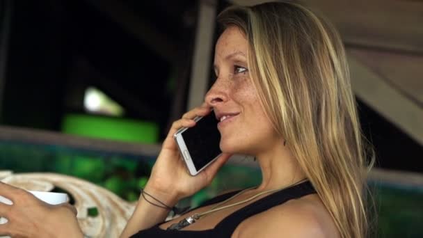Femme parlant sur le téléphone portable sur le canapé sur la terrasse — Video
