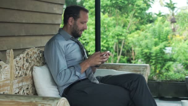 Affärsman arbetar med smartphone på terrassen — Stockvideo