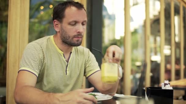 Мужчина сидит в кафе — стоковое видео