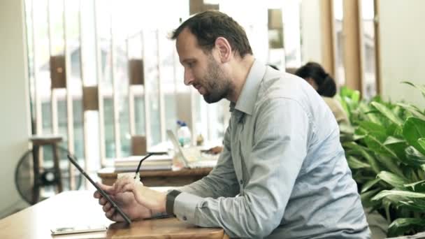 Людина з планшетним комп'ютером в кафе — стокове відео