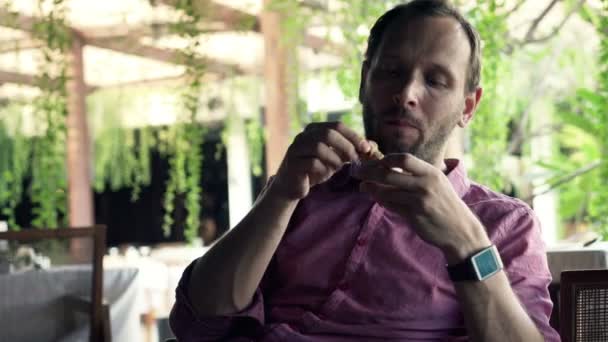 Mann isst Imbiss in Café — Stockvideo