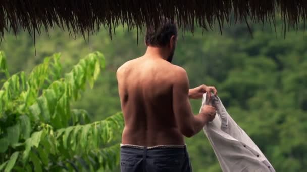 Hombre poniéndose la camisa en la terraza — Vídeos de Stock