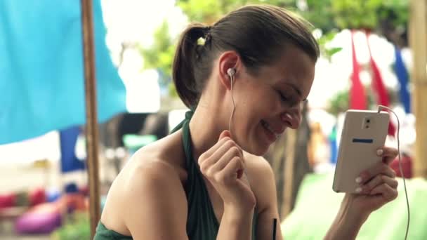 Mujer escuchar música en el bar de playa — Vídeos de Stock