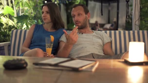 Couple sitting in cafe at night — Stock Video