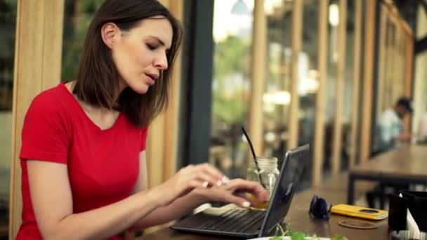 Mujer usando el ordenador portátil y beber cóctel — Vídeo de stock