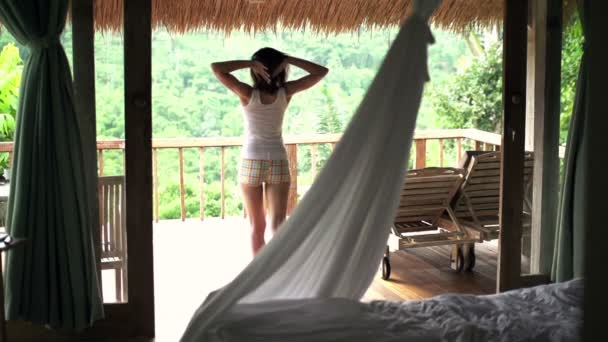 Frau wacht auf Terrasse auf und streckt Arme aus — Stockvideo