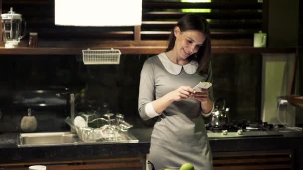 Businesswoman with smartphone in kitchen — Stock Video