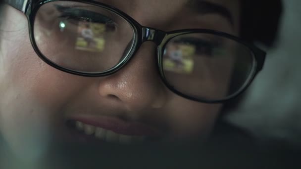Женщина в очках просматривает фотографии на планшетном компьютере — стоковое видео