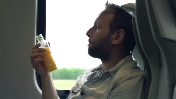 Hombre beber jugo de naranja durante viaje en tren — Vídeos de Stock