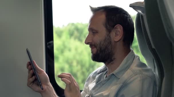 Красавчик, работающий с планшетом в поезде — стоковое видео