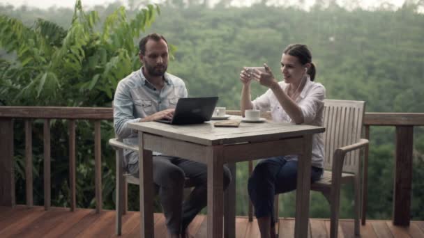 Hombre con portátil y mujer escuchando música — Vídeos de Stock