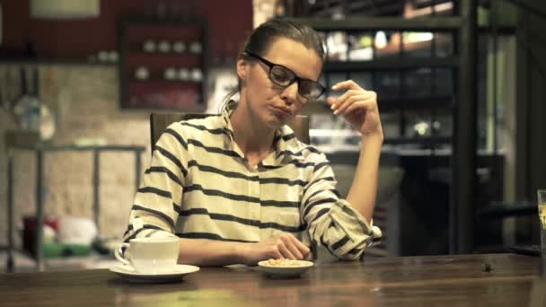 Mujer sentada en la cocina por la noche — Vídeos de Stock