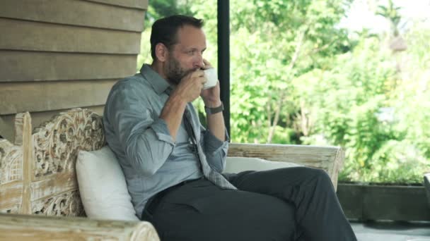 ビジネスマンが携帯電話で話していると、コーヒーを飲みながら — ストック動画