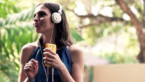 Mujer cantando y escuchando música en el teléfono celular — Vídeos de Stock