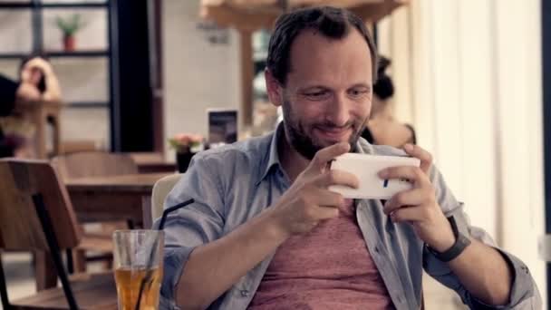 Hombre jugando juego en el teléfono inteligente — Vídeos de Stock