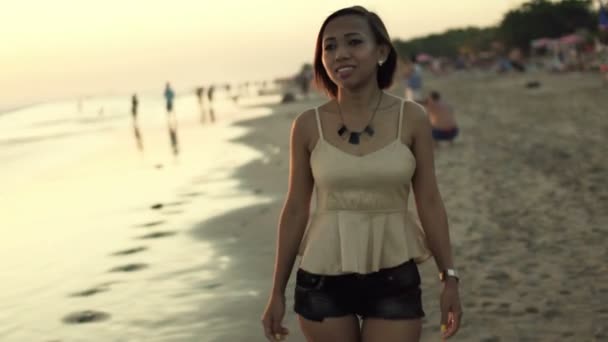 Mujer caminando por la playa al atardecer — Vídeos de Stock