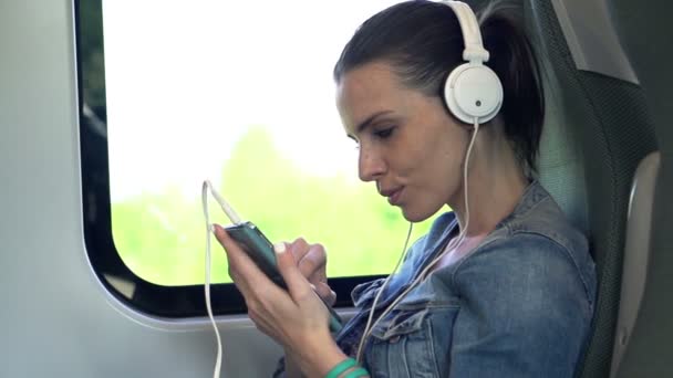 Vrouw luisteren naar de muziek tijdens het reizen per trein — Stockvideo