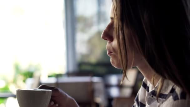 Frau trinkt Kaffee im Café — Stockvideo