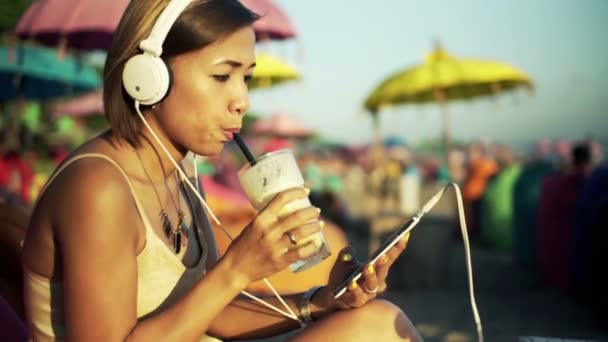 Vrouw luisteren naar muziek en drinken van cocktail — Stockvideo